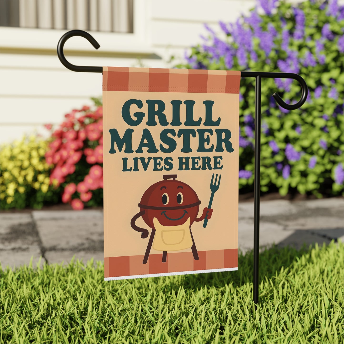 Garden flag with 'Grill Master Lives Here' text and cartoon style image of a smiling grill holding a grill fork.
